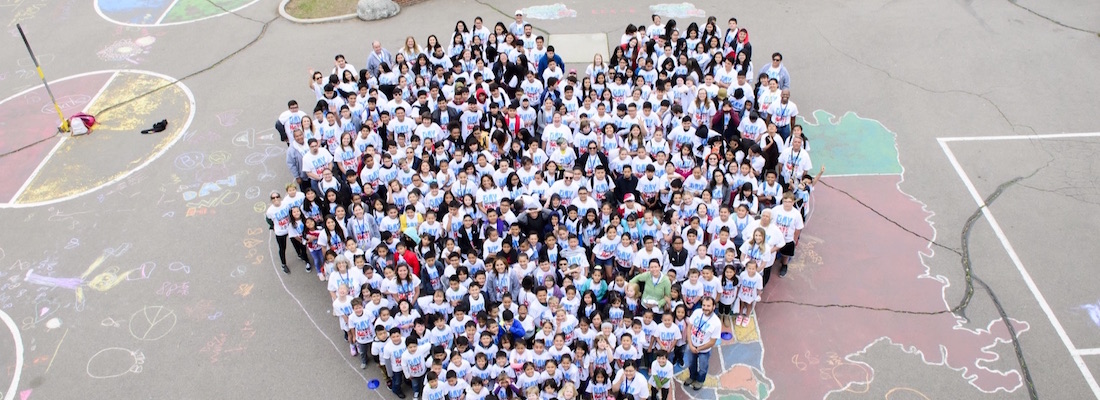 Students and staff standing outside in heart shape